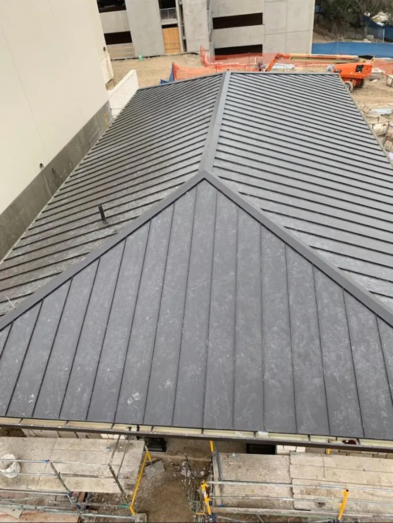 Commercial metal roof construction with crane equipment in Orange